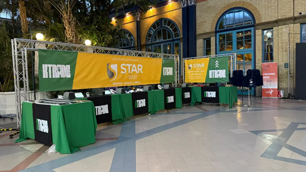 A truss gantry over a row of branded tables